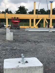 Implantation des chevillages sur massif béton pour recevoir des pieds de poteaux. Site Boulanger à Lesquin dans le département du Nord en région Hauts-de-France